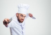 Polémique | Violence en cuisine, un reportage France 2 accablant ! Portrait of angry chef cook holding knifes @ credit Depositphotos