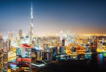 Ouvertures, EAU | Hilton développe son portefeuille émirati avec le lancement de la marque Embassy Suite by Hilton et l’ouverture du Hilton Garden Inn à Dubaï Aerial panorama view of a big futuristic city by night. Business bay, Dubai, United Arab Emirates. Colorful nighttime skyline. @ credit Depositphotos