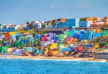 Ouverture 2025, Puerto Rico, USA |VERANÓ Hotels + Resorts annonce à San Juan, le premier établissement Leading Hotels of the World® Maisons colorées bordent la colline surplombant la plage de San Juan, Puerto Rico @ credit Depositphotos