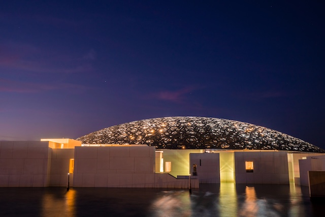 Louvre, Abu Dhabi, United Arab Emirates - May 10, 2020. The famous Louvre museum of the French architect Jean Nouvel - panoramic view from the tribune at night.