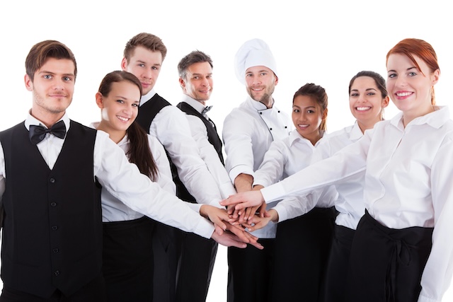 Waiters and waitresses stacking hands