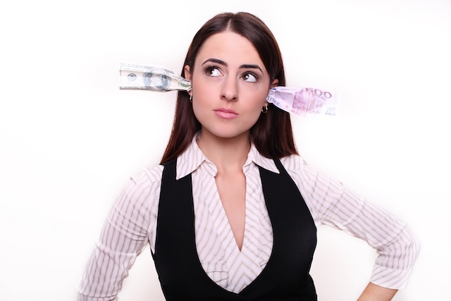 Corruption. It will keep me quiet. Bribery concept in politics, business, diplomacy. Corporate businesswoman plugs her ears with dollar banknotes, bills, covers her mouth, isolated white background