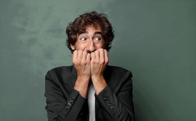 looking worried, anxious, stressed and afraid, biting fingernails and looking to lateral copy space