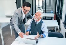 Débat | L’avenir des directions hôtelières passe-t-il par le leadership intergénérationnel ? Senior boss happy for good online work result of young male businessman.
