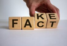 Décryptage | Marriott-Rosewood : entre rumeur d’acquisition et scepticisme des observateurs Business and design concept. Man hand flips wooden cubes with words 'FACT FAKE' concept on beautiful white background, copy space.