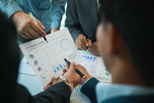 group businessmen and investors met together in conference room to view annual results their investments in business together in order to plan marketing doing business that would produce better result
